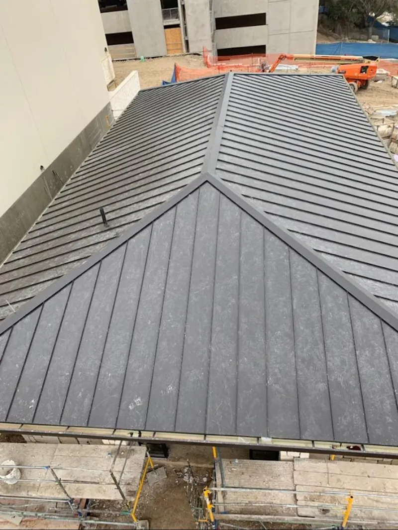 Commercial metal roof construction with crane equipment in Belleville